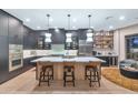 Contemporary kitchen with a large center island, pendant lighting, and stainless steel appliances at 7438 E San Jacinto Dr, Scottsdale, AZ 85258