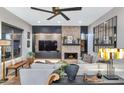 Modern living room with a stone fireplace, large sectional sofa, and stylish decor at 7438 E San Jacinto Dr, Scottsdale, AZ 85258