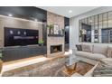 Cozy living room featuring a fireplace, plush sofa, modern entertainment center and decorative mirror at 7438 E San Jacinto Dr, Scottsdale, AZ 85258