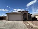 Front exterior view features a two-car garage, desert landscaping, and stucco construction at 7664 W Vermont Ave, Glendale, AZ 85303