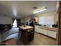 Features an island, a double sink, wood-style vinyl flooring, and lots of lighting at 7664 W Vermont Ave, Glendale, AZ 85303