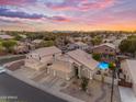 An aerial view showcases the home's location within the community, with a vibrant pool and a picturesque sunset at 780 S Lagoon Dr, Gilbert, AZ 85233