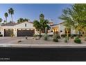 Charming home exterior with a three-car garage, desert landscaping, and a well-maintained lawn at 7902 E Via Linda --, Scottsdale, AZ 85258