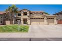 Charming two-story home with a well-manicured lawn, three-car garage and beautiful desert landscaping at 10234 E Lomita Ave, Mesa, AZ 85209