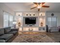 Bright living room features a large built-in entertainment center, modern lighting, and neutral color palette at 10850 W Bronco Trl, Peoria, AZ 85383