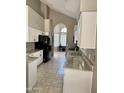 Bright kitchen with granite counters, white cabinets, tile floors, and modern black appliances at 11001 Clear Water --, Goodyear, AZ 85338