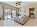 Bright living room with neutral decor, tile floors and large sliding glass doors to backyard at 13811 W Paso Trl, Peoria, AZ 85383