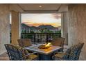Cozy outdoor fireplace on the balcony, perfect for enjoying scenic mountain views at sunset at 2 Biltmore Est # 309, Phoenix, AZ 85016