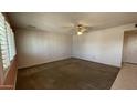 Another view of the spacious living room, featuring a ceiling fan and neutral carpeting at 2137 W Del Campo Cir, Mesa, AZ 85202