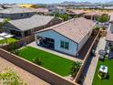 Well-maintained backyard featuring green turf, a covered patio, and block wall fencing for privacy at 21595 S 225Th Way, Queen Creek, AZ 85142