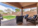 Outdoor living space features comfortable seating under a covered patio, perfect for relaxation and enjoying the backyard view at 21950 N Dietz Dr, Maricopa, AZ 85138