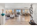 Expansive living room featuring art, sleek furnishings, travertine floors, and large windows with city views at 2211 E Camelback Rd # 1203, Phoenix, AZ 85016