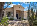 Charming home featuring a blue entry door, tiled roof, desert landscaping, and an attached garage at 22231 N 51St St, Phoenix, AZ 85054