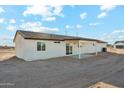 Rear exterior view of a single-story home with a covered patio and desert landscape at 22387 S Manzanilla Rd, Buckeye, AZ 85326
