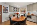 A modern dining area features a round wooden table with seating and built-in shelving at 2300 E Campbell Ave # 104, Phoenix, AZ 85016