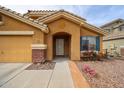 Exterior view of a single-story home featuring a covered entryway, desert landscaping, and a two-car garage at 23814 W Chambers W St, Buckeye, AZ 85326