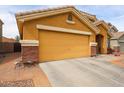 Two-car garage with brick-trimmed facade and driveway at 23814 W Chambers W St, Buckeye, AZ 85326