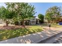 Two-story home with landscaped yard, mature trees, and a charming front porch at 2438 N Forest Cir, Mesa, AZ 85203