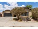 Charming single-story home featuring desert landscaping, a two-car garage, and an inviting facade on a sunny day at 25212 W Maldonado Dr, Buckeye, AZ 85326