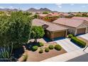 An aerial view of a well-landscaped home with a manicured lawn, tile roof and desert landscaping at 26071 W Sequoia Dr, Buckeye, AZ 85396