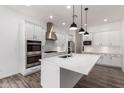 A bright kitchen is showcased with white cabinets, stainless steel appliances, a center island, and pendant lighting at 26860 N 102Nd Ln, Peoria, AZ 85383
