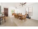 Bright dining room with ceiling fans, large windows, and a wooden table with seating for eight at 29339 N 67Th Ave, Peoria, AZ 85383