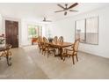 Spacious dining room featuring a classic wood table set under a ceiling fan and natural light from large windows at 29339 N 67Th Ave, Peoria, AZ 85383