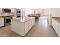 Open concept kitchen featuring white cabinets, stainless steel appliances, and a central island at 29339 N 67Th Ave, Peoria, AZ 85383