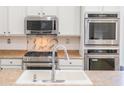 Close up of the kitchen showing the oven, microwave, sink and fixtures at 29339 N 67Th Ave, Peoria, AZ 85383