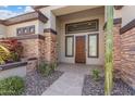 Inviting front entrance featuring stone accents, desert plants, and a decorative wood door at 4589 N 154Th Ave, Goodyear, AZ 85395