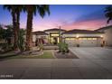 Twilight exterior view highlighting desert landscaping and a three-car garage at 4589 N 154Th Ave, Goodyear, AZ 85395