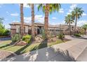 Gorgeous front exterior showing lush desert landscaping including mature palms and multiple cacti at 4589 N 154Th Ave, Goodyear, AZ 85395