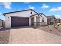Attractive home showcasing desert landscaping, neutral tones, and a brick-paved driveway to the two car garage at 4811 W Hunter Trl, San Tan Valley, AZ 85144