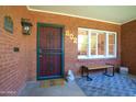 Welcoming front porch featuring a secure door, a bench and brick accent wall at 502 W Windsor Ave, Phoenix, AZ 85003