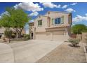 Two-story stucco home with three-car garage and desert landscaping at 5440 W Apollo Rd, Laveen, AZ 85339