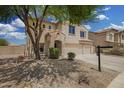 Two-story stucco home with a three car garage and desert landscaping at 5440 W Apollo Rd, Laveen, AZ 85339