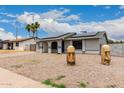 Single-story home featuring solar panels, a xeriscaped front yard, and eye-catching decor at 5702 S Beck Ave, Tempe, AZ 85283