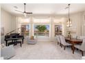 Open-concept living and dining area with piano, large windows, and view to the backyard pool at 6135 E Campo Bello Dr, Scottsdale, AZ 85254