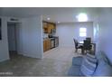 Bright living room featuring tile floors, neutral walls, and a dining area adjacent to an updated kitchen at 6725 W Cypress St, Phoenix, AZ 85035