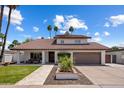Charming home featuring a well-manicured lawn, desert landscaping, tile roof, and a spacious two-car garage at 7469 E Timberlane Ct, Scottsdale, AZ 85258