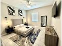 Modern bedroom features stylish decor, including a ceiling fan, unique artwork, and a sleek dresser at 8024 W State Ave, Glendale, AZ 85303