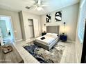 Bright bedroom with a ceiling fan, closet, large windows and stylish decor at 8024 W State Ave, Glendale, AZ 85303