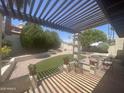 Inviting covered patio with seating area overlooking the lush backyard with artificial turf at 9406 S 47Th Pl, Phoenix, AZ 85044