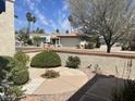 Well-manicured front yard featuring a circular garden and mature landscaping, offering curb appeal at 9406 S 47Th Pl, Phoenix, AZ 85044