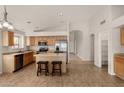 Bright eat-in kitchen featuring light wood cabinets, an island, and stainless steel appliances at 12428 W Vermont Ct, Litchfield Park, AZ 85340