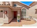 Cozy front porch with a small table and chairs, a potted plant, and a wooden front door at 13270 N 93Rd Way, Scottsdale, AZ 85260