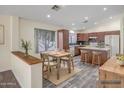 Charming kitchen with wood cabinets, stainless appliances, island, and adjacent dining area at 13416 W Ventura St, Surprise, AZ 85379