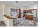 The kitchen features sleek, dark cabinets, stainless appliances, and a spacious island for prep at 13416 W Ventura St, Surprise, AZ 85379
