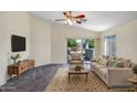 Cozy living room with vaulted ceiling, neutral decor, carpet, and sliding doors to the backyard at 13416 W Ventura St, Surprise, AZ 85379