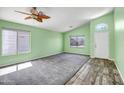 Inviting living room featuring neutral carpet, bright windows, and a stylish ceiling fan at 13416 W Ventura St, Surprise, AZ 85379